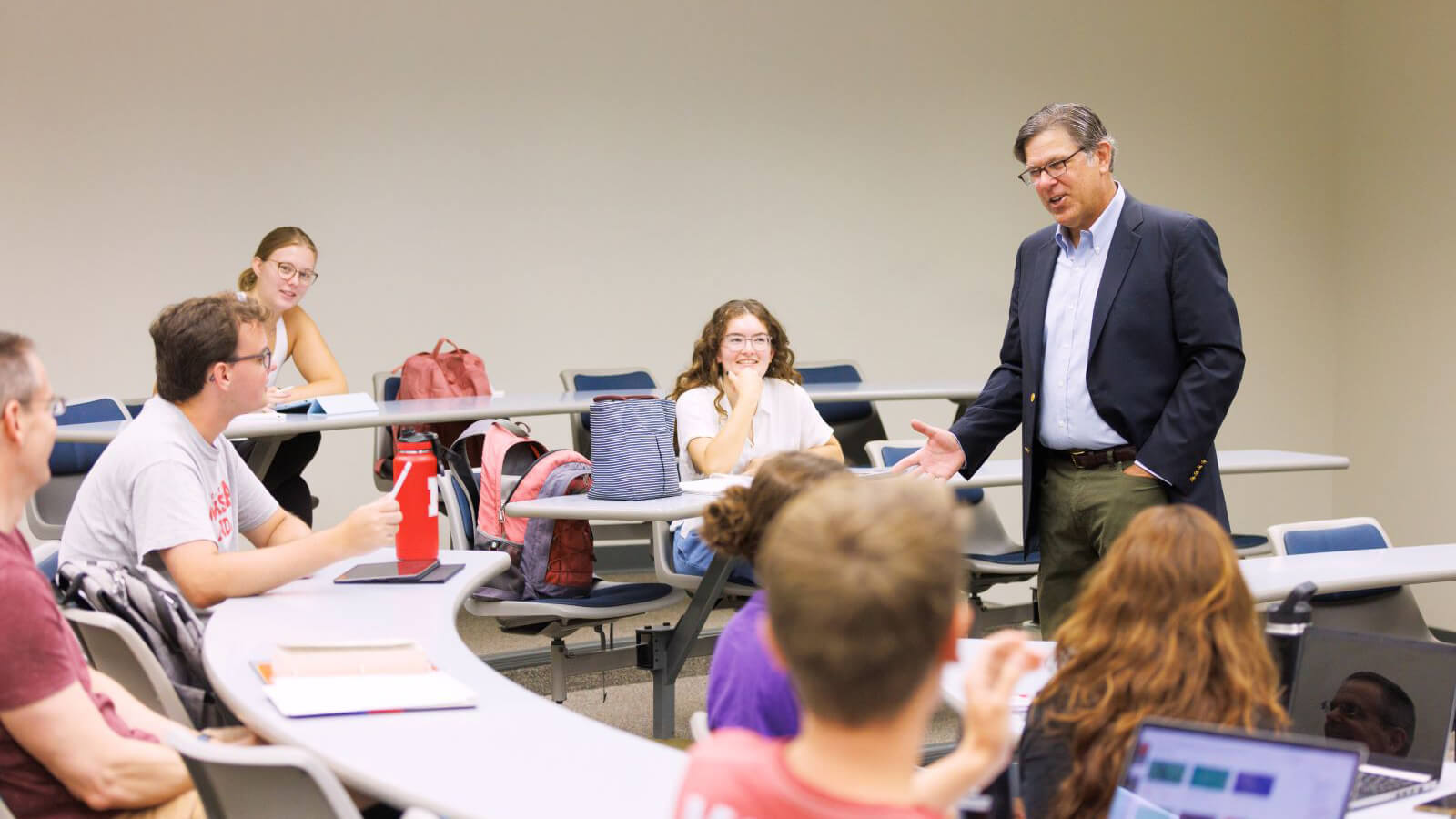 Professor lectures in front of seated students.